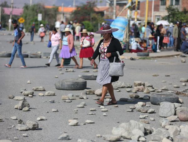 Una mujer quechua camina en una vía bloqueada por seguidores del expresidente de Bolivia Evo Morales este lunes, en Sipe Sipe (Bolivia). Subidos en cerros para arrojar piedras grandes a los policías y armados con dinamitas y palos, los seguidores de Morales (2006-2019) cumplen este lunes quince días de bloqueo de carreteras que intensificaron en el centro del país en defensa de su líder ante una posible orden de captura. EFE/ Luis Gandarillas