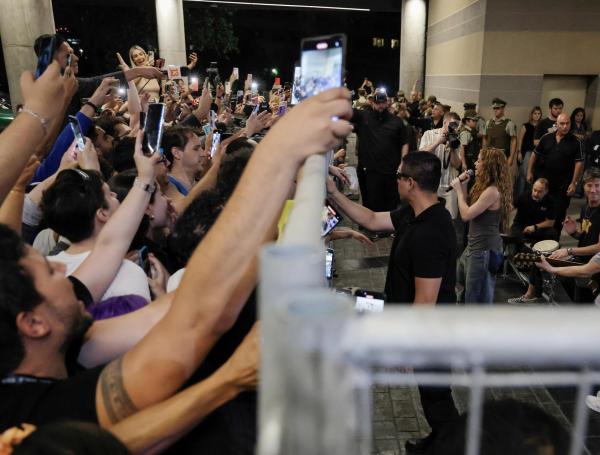 a cantante colombiana Shakira (d) canta a sus seguidores frente al Hotel Mandarin, donde se alojaba tras la cancelación de sus dos conciertos en Chile