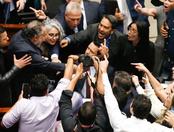 El ministro del Interior es sujetado por el senador 'Jota P' Hernández.