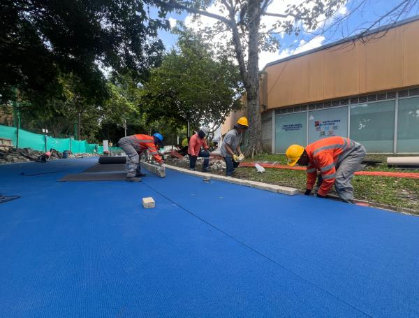 Proceso de instalación del tapete de la pista de trote.