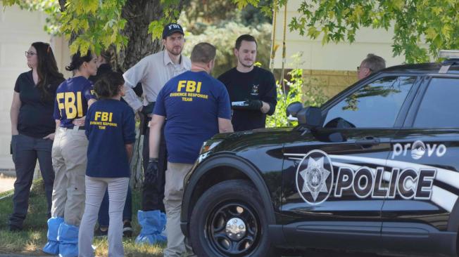 Funcionarios del FBI se paran afuera de la casa de Craig Robertson, quien fue muerto a tiros por el FBI en Provo, Utah.