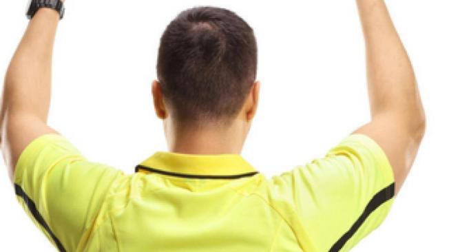 Arbitro pita con tobillera electrónica.