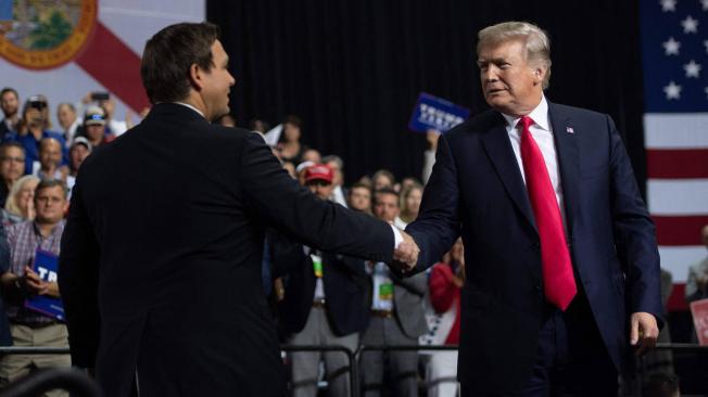 El expresidente de Estados Unidos, Donald Trump, estrecha la mano del gobernador Ron DeSantis.