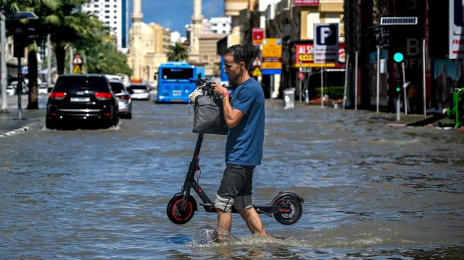 Un hombre cruza una calle inundada tras las fuertes lluvias en Sharjah el 17 de abril de 2024.