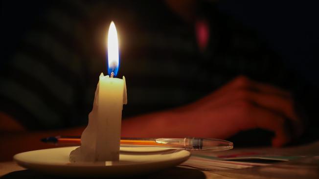 Un estudiante lee un texto a la luz de una vela en Quito (Ecuador).