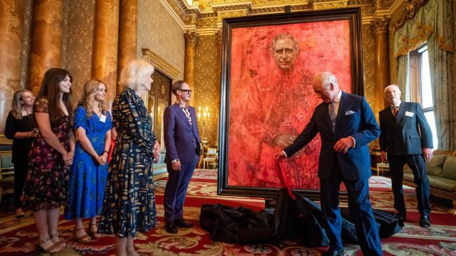 La Reina Camilla de Gran Bretaña (3L) observa cómo el Rey Carlos III de Gran Bretaña (2R) desvela un retrato oficial de sí mismo, realizado por el artista Jonathan Yeo (5L), representado con el uniforme de la Guardia Galesa, de la que fue nombrado Coronel del Regimiento en 1975. en el Salón Azul del Palacio de Buckingham en Londres el 14 de mayo de 2024. El retrato oficial fue encargado en 2020 para celebrar los 50 años del entonces Príncipe de Gales como miembro de The Drapers' Company en 2022. El artista Jonathan Yeo tuvo cuatro sesiones con el Rey Carlos III, comenzando cuando era Príncipe de Gales en junio de 2021 en Highgrove, y luego en Clarence House. La última sesión tuvo lugar en noviembre de 2023 en Clarence House. Yeo también trabajó a partir de dibujos y fotografías que tomó, lo que le permitió trabajar en el retrato en su estudio de Londres entre sesiones. El tamaño del lienzo (aproximadamente 8,5 por 6,5 pies cuando está enmarcado) se consideró cuidadosamente para que encajara dentro de la arquitectura de Drapers' Hall y el contexto de las pinturas que eventualmente colgará junto a él. (Foto de Aaron Chown / POOL / AFP) / RESTRINGIDO A USO EDITORIAL - MENCIÓN OBLIGATORIA DEL ARTISTA AL MOMENTO DE LA PUBLICACIÓN - PARA ILUSTRAR EL EVENTO COMO SE ESPECIFICA EN EL TÍTULO.