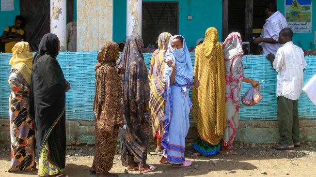 Sudaneses desplazados internamente hacen fila para recibir comida.