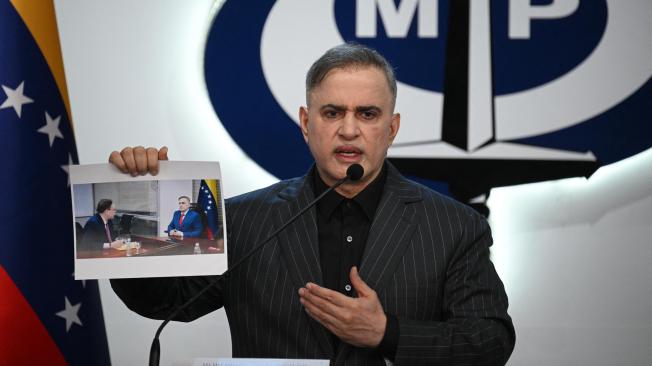 El fiscal general de Venezuela, Tarek William Saab, muestra una imagen de su reunión con el abogado del opositor Edmundo González.