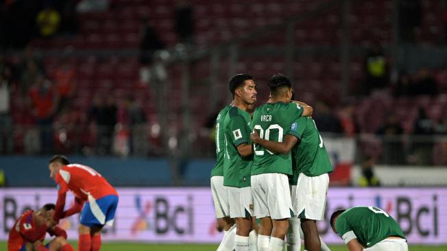 TOPSHOT - Players of Bolivia celebrate after winning the 2026 FIFA World Cup South American qualifiers football match between Chile and Bolivia, at the National stadium in Santiago, on September 10, 2024. (Photo by Rodrigo ARANGUA / AFP)