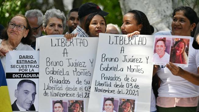 Manifestantes sostienen carteles para exigir la libertad de los presos políticos durante una protesta ante la embajada de Brasil en Caracas.