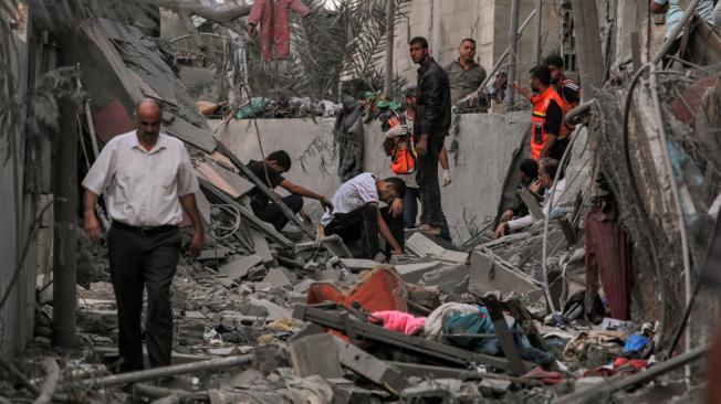 Rescatistas de la Defensa Civil Palestina y otras personas entre los escombros de un edificio derrumbado en Jan Yunis, en el sur de la Franja de Gaza.