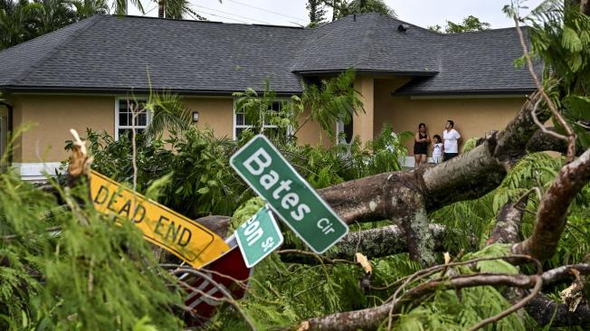Oscar García con su familia se encuentra afuera de su casa después de ser azotado por un tornado en Fort Myers, Florida, el 9 de octubre de 2024.