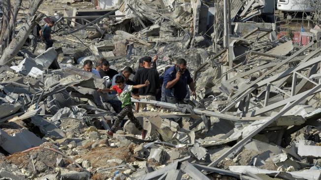 La gente inspecciona los daños en el lugar de un ataque aéreo israelí en la zona de Ouzai, cerca de la pista del aeropuerto de Beirut, en el sur de Beirut, Líbano, el 7 de noviembre de 2024.