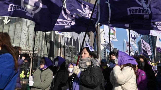 Las mujeres surcoreanas portan banderas que dicen "Feminista" mientras marchan durante una manifestación para conmemorar el Día Internacional de la Mujer en el centro de Seúl el 8 de marzo de 2024.