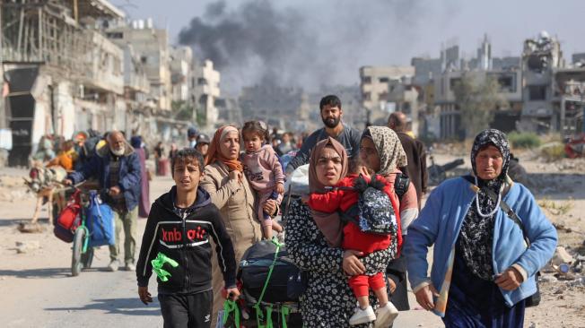 Palestinos desplazados de los refugios de Beit Hanoun cruzan la carretera principal de Salaheddine hacia Jabalia, en el norte de la Franja de Gaza.