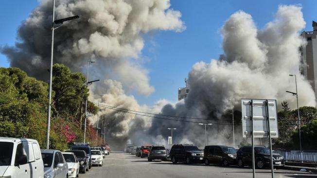 El humo envuelve una calle tras un ataque israelí contra un edificio en el barrio de Ghobeiri, en el sur de Beirut.