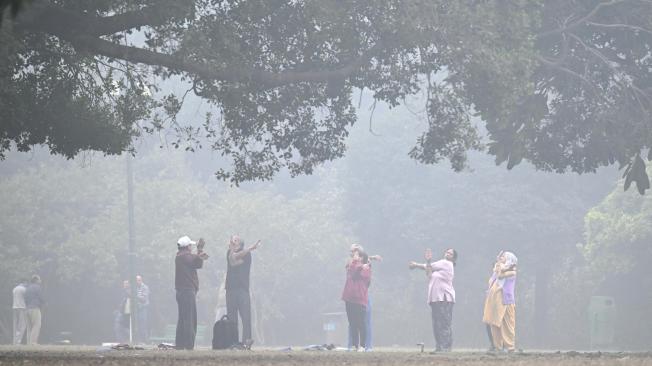 La gente hace ejercicio en los jardines de Lodhi en una mañana fría y llena de smog en Nueva Delhi el 18 de noviembre de 2024.