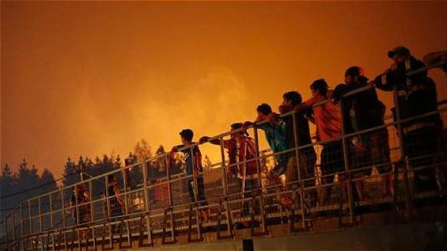 Los bomberos y la población civil observan uno de los incendios en Chile.Pablo Vera Lisperguer /AFP