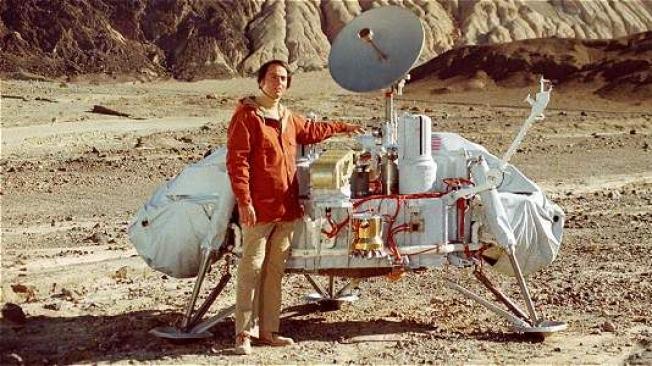Carl Sagan junto a un modelo de la sonda Viking, que exploró el planeta Marte.