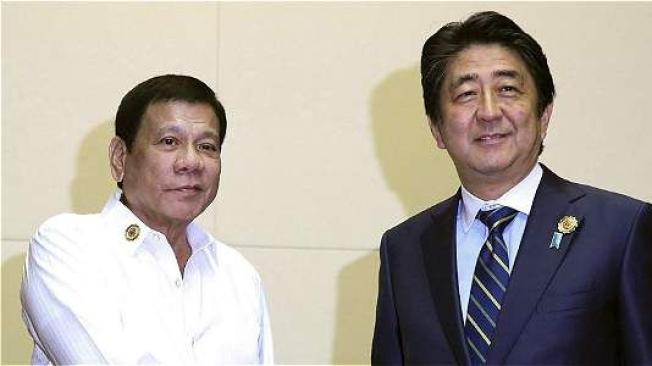 EL presidente filipino, Rodrigo Duterte (izq), y el primer ministro japonés, Shinzo Abe (der), durante su reunión en el marco de la cumbre de la Asociación de Naciones del Sudeste Asiático (ASEAN).