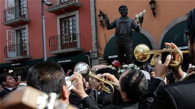 Cientos de personas lloran y cantan las canciones de Juan Gabriel al pie de su escultura en la Plaza Garibaldi en Ciudad de México. Foto: REUTERS
