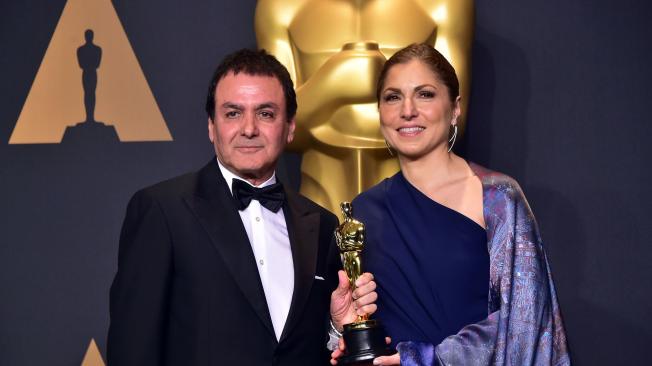 Firouz Naderi (izq.) y Anousheh Ansari (der.) reciben el Óscar, en nombre del cineasta iraní Asghar Farhadi.