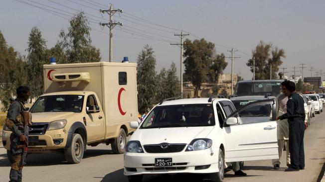Oficiales de seguridad de Afganistán registran varios carros en un puesto de control en Helmand.