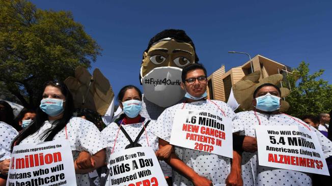 Vestidos como pacientes de un hospital, varias personas marcharon ayer en Los Ángeles (EE. UU.) para defender el ‘obamacare’.