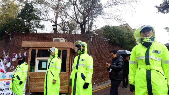Policías hacen guardia fuera de la casa de la líder derrocada de Corea del Sur, Park Geun-hye.