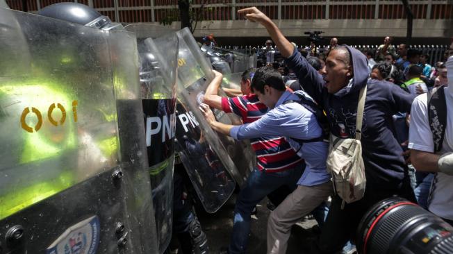 Manifestantes, opositores al Gobierno de Maduro, se enfrentan a las autoridades.
