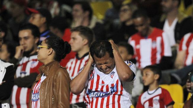 Hinchas de Junior se lamentan con el gol que recibió su equipo en Bogotá.