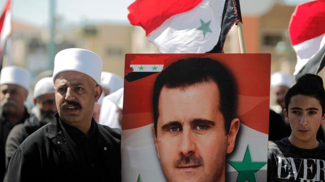 El presidente sirio, Bashar al Asad (foto pancarta), niega tener armas químicas.