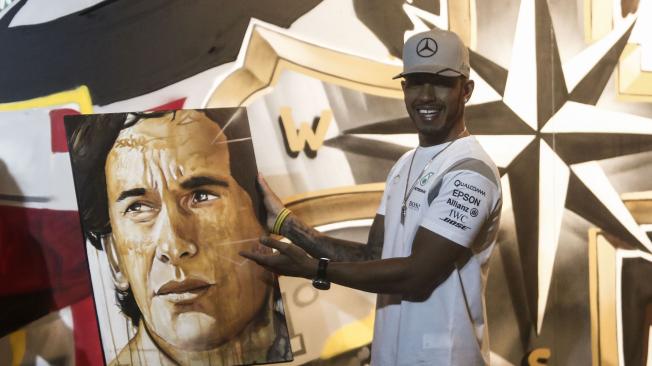 Lewis Hamilton con una pintura de la leyenda, Ayrton Senna