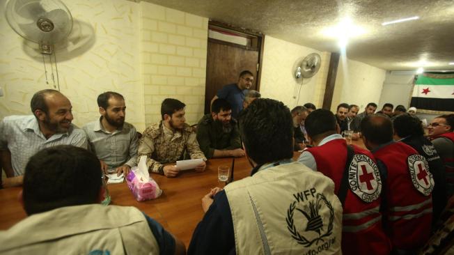 Personal de agencias de la ONU discuten la situación en Douma con representantes de un convoy de camiones que transportaba suministros de ayuda humanitaria bajo la supervisión de las Naciones Unidas, la Media Luna Roja Siria.