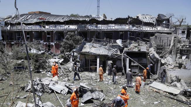 Operarios retiran los escombros junto a uno de los edificios que resultaron dañados tras el atentado suicida perpetrado cerca al palacio presidencial en Kabul, el más mortífero desde 2001.
