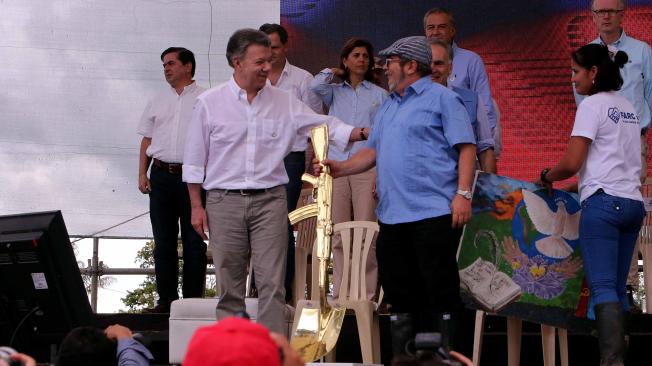 El presidente de Colombia, Juan Manuel Santos, conversa con el jefe de las Farc, Rodrigo Londoño, alias Timochenko, durante la ceremonia de dejación de armas de ese grupo.