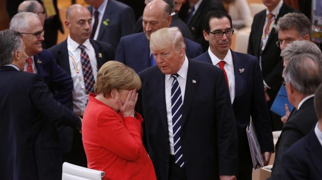 El presidente estadounidense, Donald J. Trump (c) ,conversa con la canciller alemana, Angela Merkel (i), durante la sesión plenaria de la cumbre de líderes de estado y gobierno del G20, en Hamburgo.