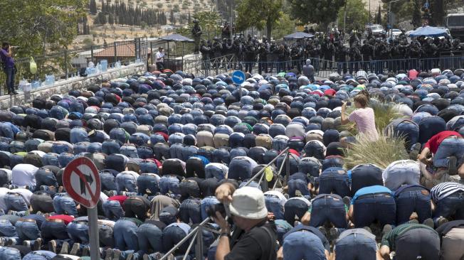 Miles de palestinos se agruparon en los accesos a la Explanada de las Mezquitas de Jerusalén para rezar, frente a un muro de policías israelíes desplegados para impedir el ingreso a lugar santo.