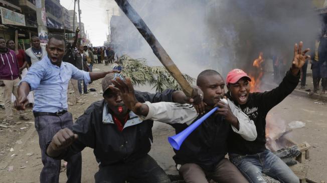 Simpatizantes del líder de la oposición, Raila Odinga, protestan sentados en una barricada en llamas por los resultados de las elecciones generales, que dan como ganador al