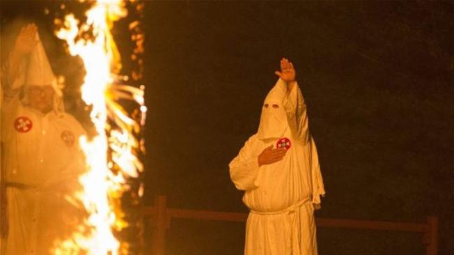 Saludo nazi de un integrante del 'Ku Klux Klan' frente a una de las cruces ardientes en la ceremonia. Este es uno de los ritos comunes que tiene el ‘KKK’.