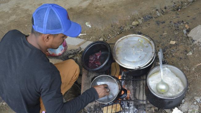 Con improvisados fogones hechos con ladrillos y material reciclado, los afectados por el incendio cocinan los alimentos para disfrutar con sus familiares.
