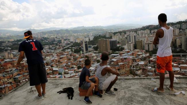 Un grupo de jóvenes en el techo de una vivienda en el barrio de Petare, en Caracas. (Foto: Andrés Martínez Casares/Reuters).