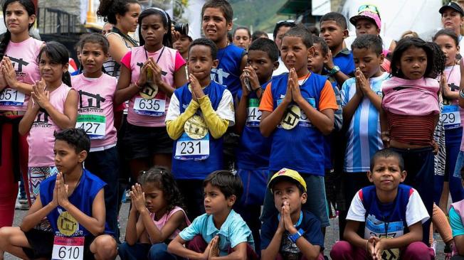 Este grupo de niños participó en una clase de yoga, tras competir en la “Carrera por la paz”, en el barrio de Petare en el marco del Día de la No Violencia, el 2 de octubre de 2016. (Foto: Fedérico Parra/AFP/Getty Images).