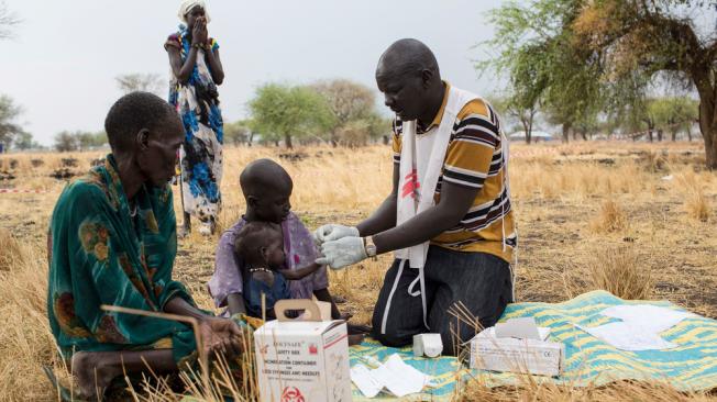 El promotor comunitario de salud, Gatbel, examina a un niño por paludismo en una clínica externa en Thaker, Sudán del Sur.