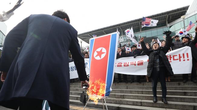 Manifestantes protestan quemando banderas de Corea del Norte, en rechazo a la visita de una delegación de ese país a Seúl, Corea del Sur.