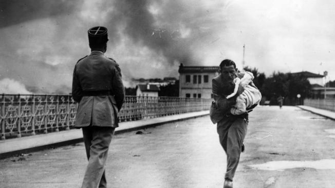 La frontera entre Francia y España no siempre fue pacífica. En la imagen, el periodista Raymond Walker, corre con un bebé en brazos sobre un puente entre Hendaya e Irún en plena guerra civil española.
