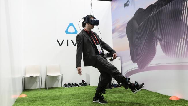Un asistente usa un casco Vive de realidad virtual (VR) y sensores, fabricados por HTC Corp., para jugar fútbol virtual. La realidad virtual y el Internet de las Cosas (IoT) son algunos de los principales protagonistas del MWC.