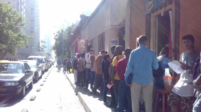 En las calles de Santiago cientos de venezolanos hacen filas para presentar sus solicitudes de empleo.
