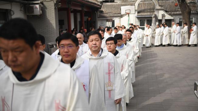 Varios clérigos católicos en una marcha de la Semana Santa en Pekín.