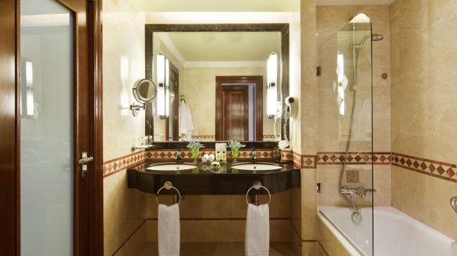 Los baños del hotel están hechos en mármol y tienen divisiones en vidrio.
